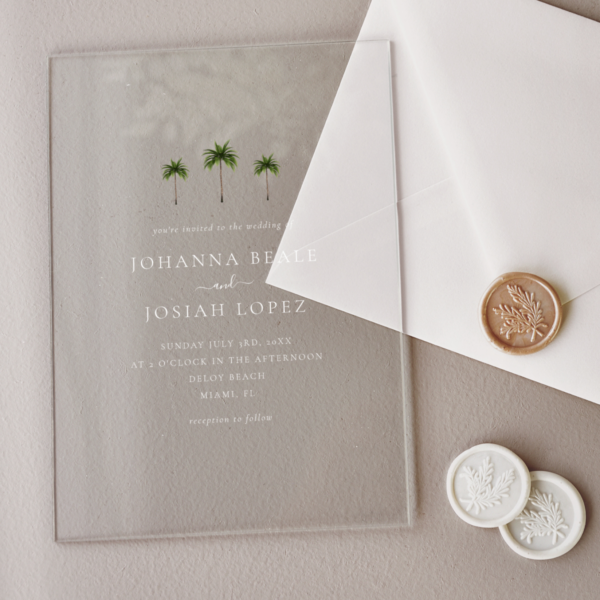modern acrylic wedding invitation surrounded by wax seals and white envelope.