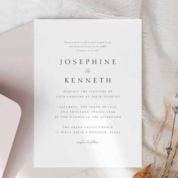 minimal wedding invitation on cloth against a simple mauve envelope and fall leaf.